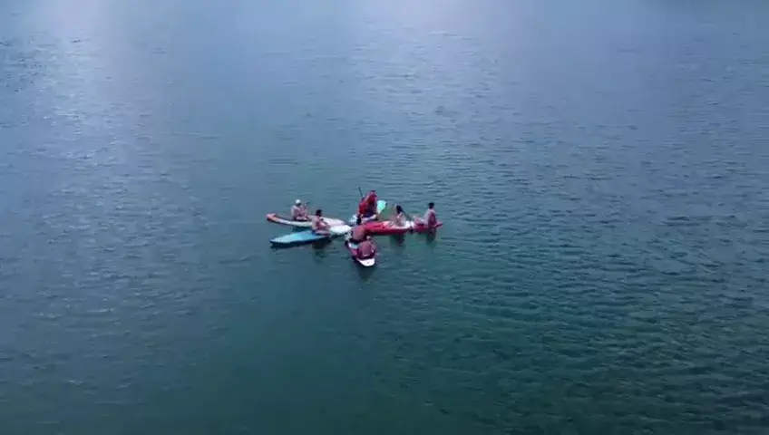 grup de turisti practicand sup si caiac pe lacul Paltinu